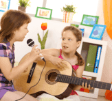 girl playing the guitar while the one is singing